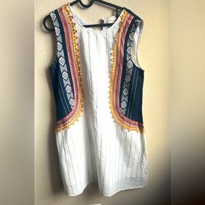 A cute straight mini white dress with some oath work and silver stripes